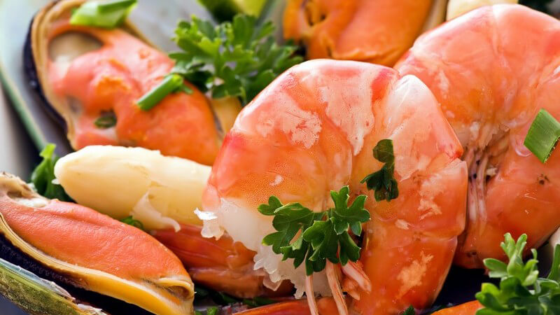 Frische Scampi müssen zunächst gewaschen und zerlegt werden; bei Tiefkühlware kommt es auf ein schonendes Auftauen an