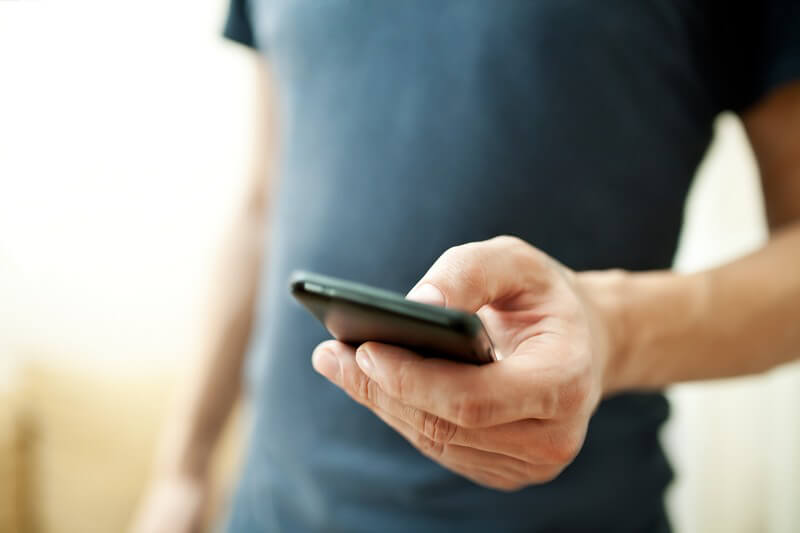 Mann hantiert an einem Smartphone Mann hantiert an einem Smartphone