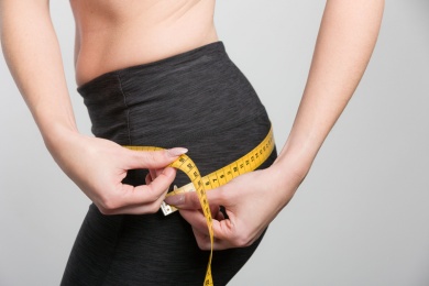 Frau misst ihren Hüftumfang