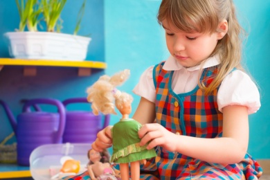 Mädchen spielt mit Puppen