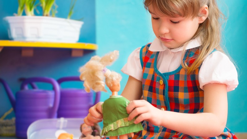 Mädchen spielt mit Puppen