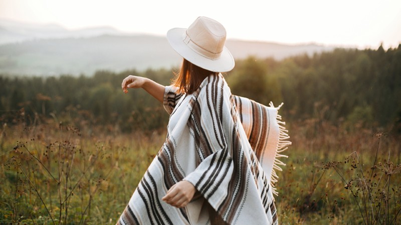 Modische Frau in gestreiftem Poncho