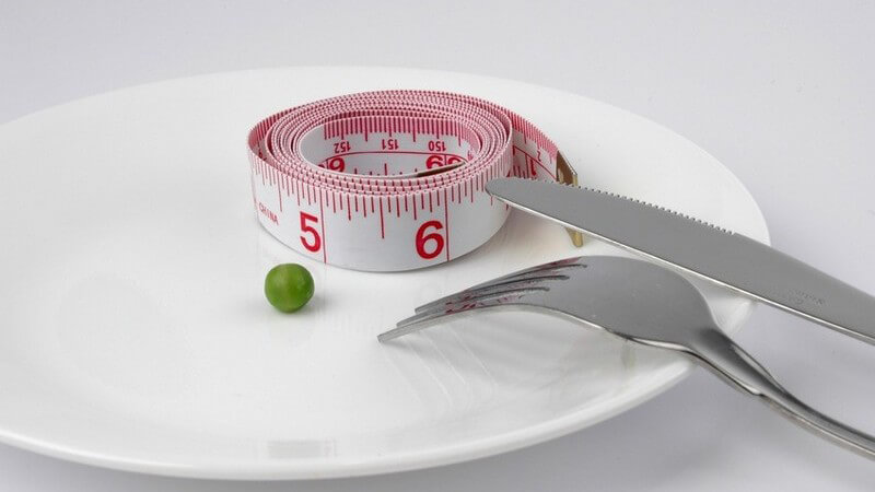 Abnehmen - Teller mit Erbse, Maßband und Besteck