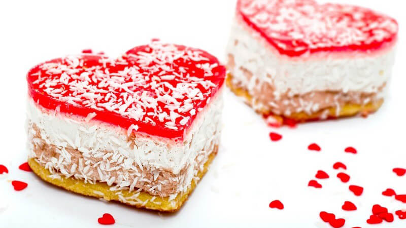 Zwei kleine Kuchen in Herzform mit Kokosraspeln