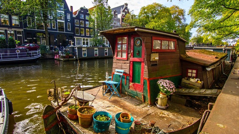 Hausboot liegt am Ufer eines Kanals in Amsterdam