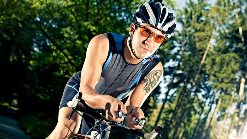 Junger Radfahrer mit Helm auf Straße