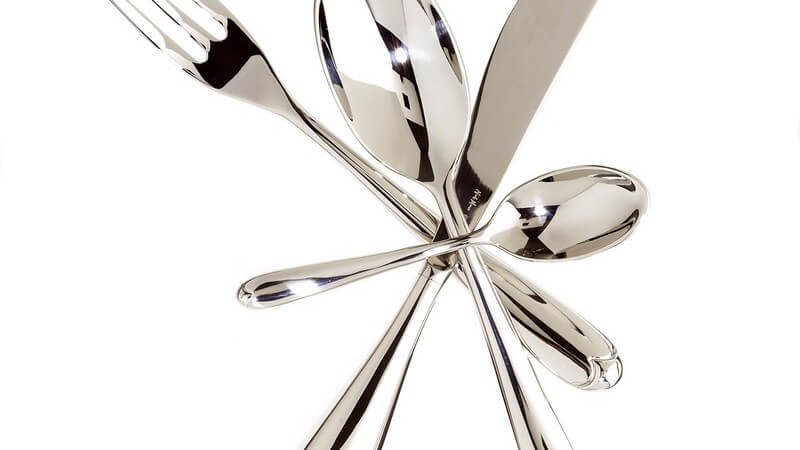 Silberbesteck im Kreis übereinander gelegt, weißer Hintergrund