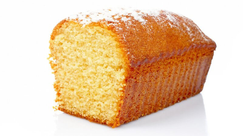 Hälfte eines frisch gebackenen Sandkuchens auf weißem Hintergrund