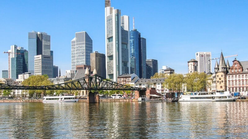 Blick über den Main auf die Skyline von Frankfurt mit dem Commerzbank Tower und der Fußgängerbrücke "Eiserner Steg"