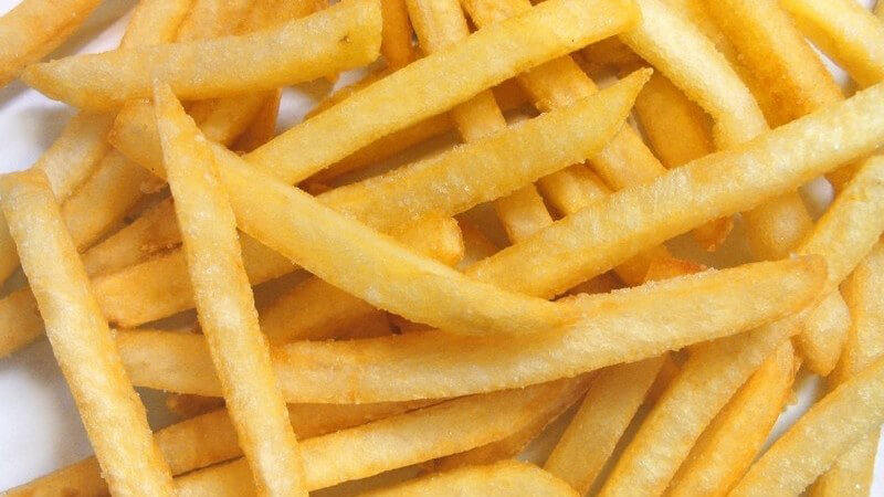 Frittierte und gesalzene Pommes auf weißem Hintergrund
