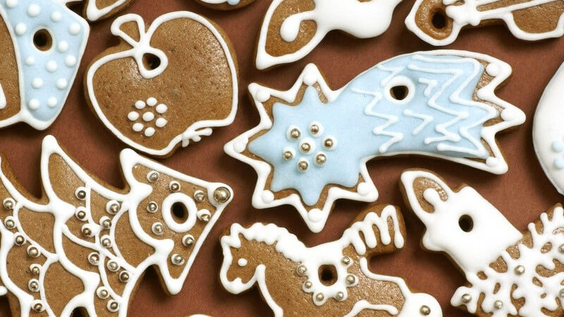 Weihnachtsplätzchen in Weihnachtsmotiven auf braunem Hintergrund