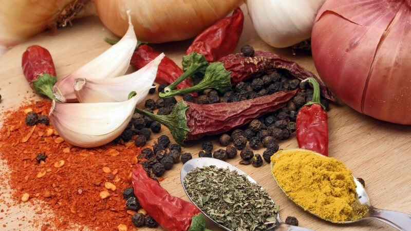 Zutaten - Zwiebeln, Knoblauch, Paprika und zwei Löffel mit Gewürzen