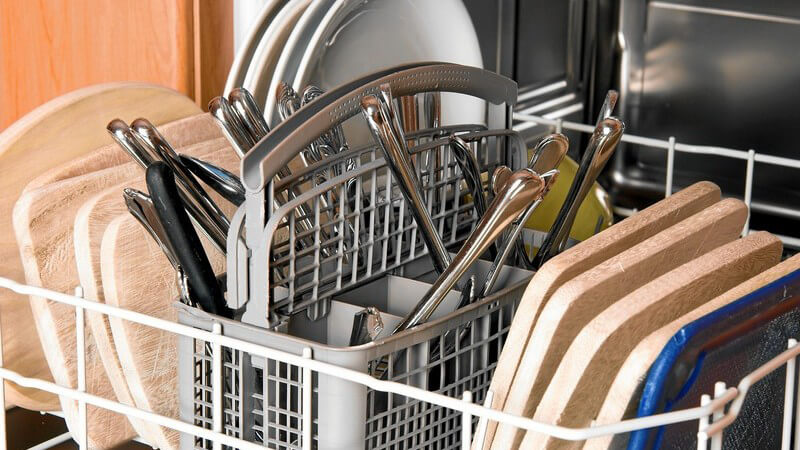 Spülmaschine mit Geschirr, Besteck und Holzbrettern