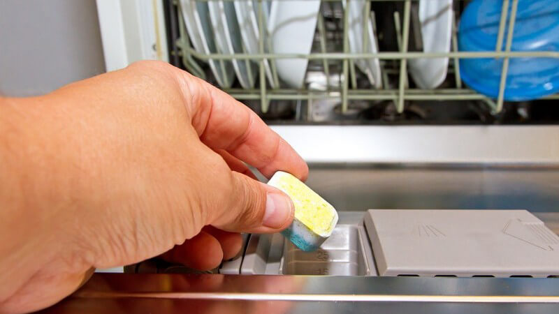 Spülmaschinen-Tab wird in Geschirrspüler gelegt