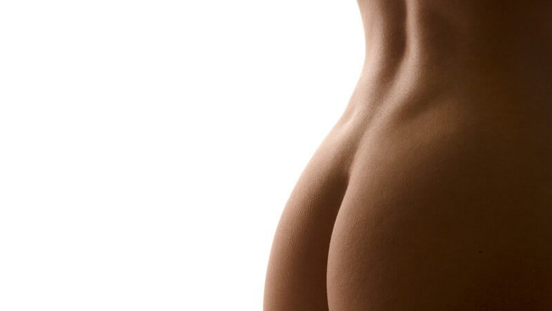 Nahaufnahme weiblicher Po mit unterem Teil des Rückens, weißer Hintergrund