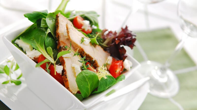 Salat mit Putenfleisch in weißer Schale
