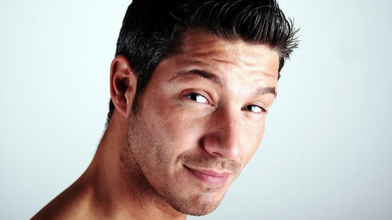 Gesicht eines dunkelhaarigen, sportlichen Mannes mit 3-Tage-Baart