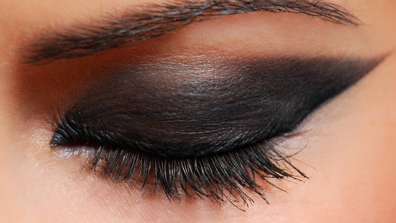 Geschlossenes weibliches Auge mit üppig geschminkten Smokey-Eyes, Lid nach oben verlängert