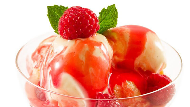Vanilleeis mit frischen Erd- und Himbeeren, roter Sauce und Minzblättern