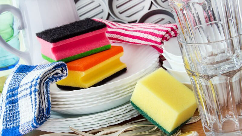 Abwasch in der Küche - gestapeltes Geschirr, Schwämme und Handtücher