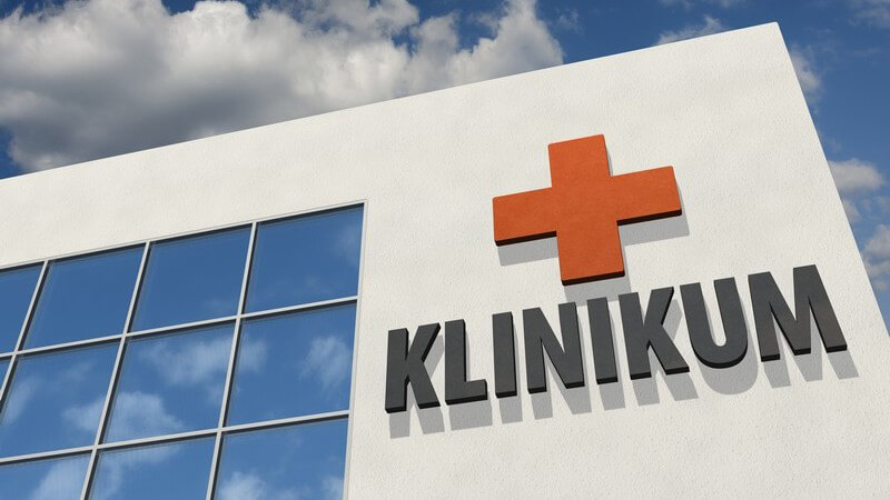Gebäudefront eines Krankenhauses mit rotem Kreuz und der Aufschrift "Klinikum"