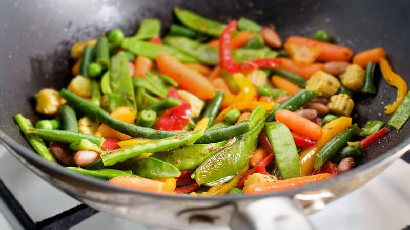 Buntes Gemüse in Wok auf Gasherd