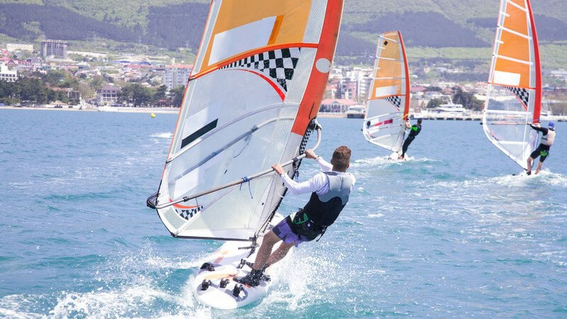 Drei Windsurfer während eines Rennens