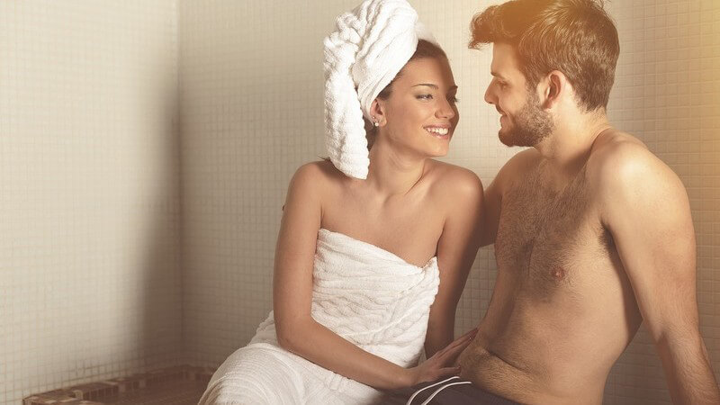 Junges Paar in einem Dampfbad, sie mit Handtuch im Haar