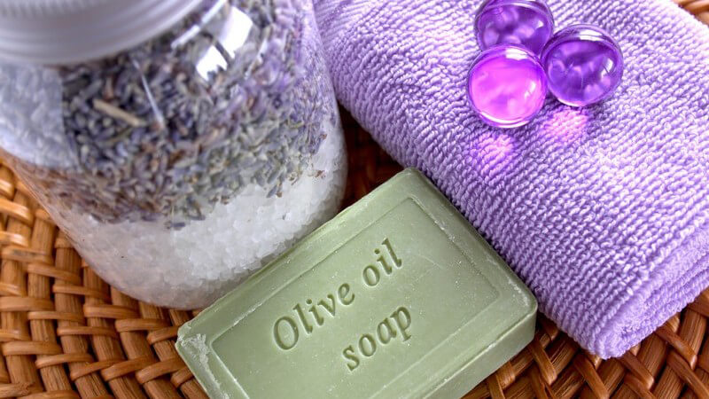 Handtuch, Badesalz und Seife auf Korbuntergrund