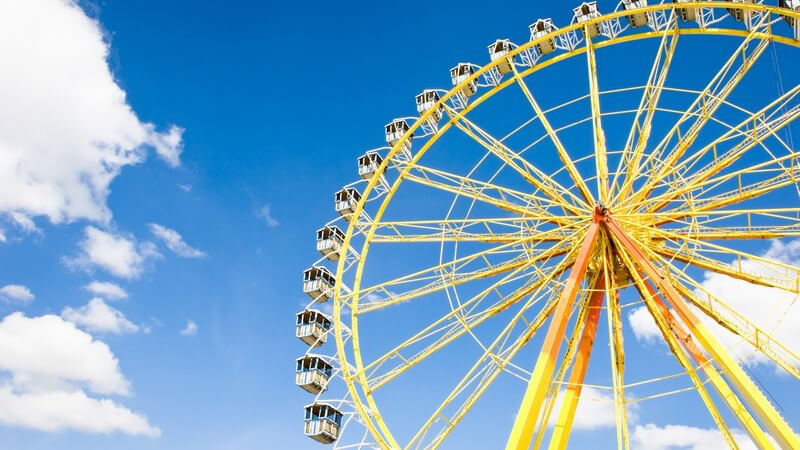 Riesenrad vor blauem Himmel auf Jahrmarkt, Oktoberfest