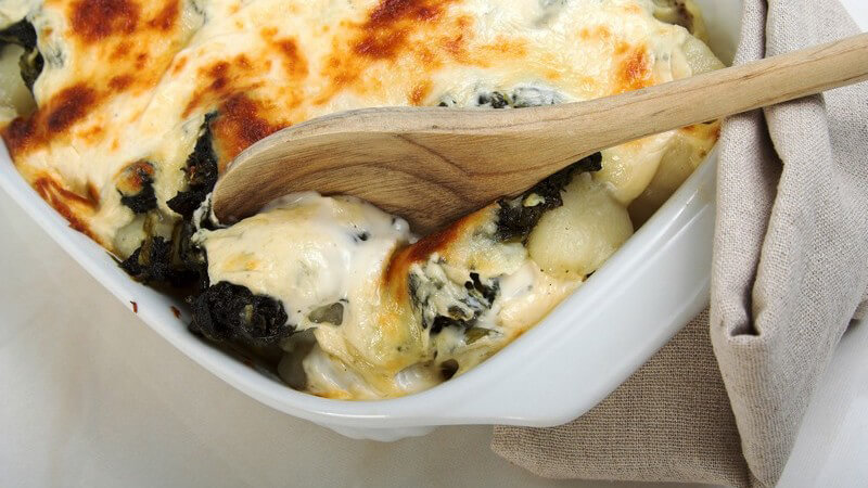 Holzlöffel in Schale mit Gnocchi Auflauf