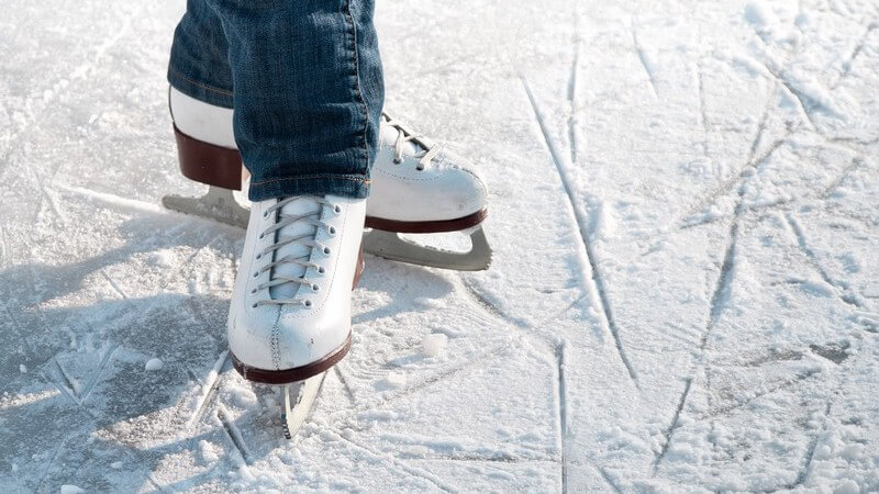 Ausschnitt Beine in Schlittschuhen auf Eisfläche