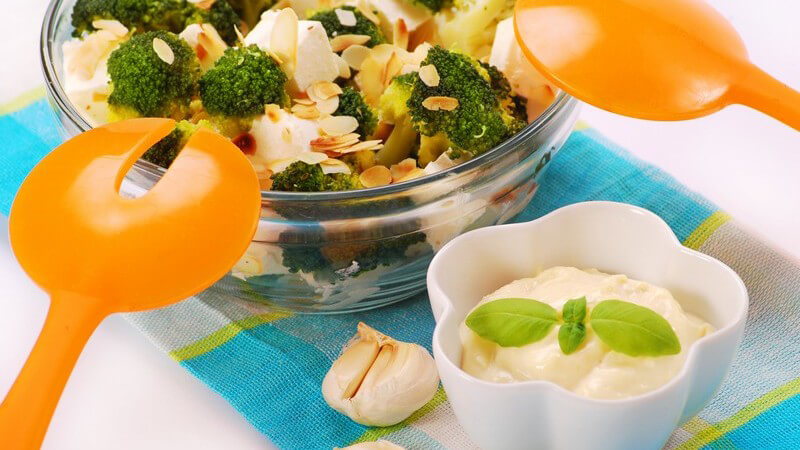 Schüssel mit Salat mit Brokkoli, Feta, daneben Schälchen mit Knoblauch-Dip