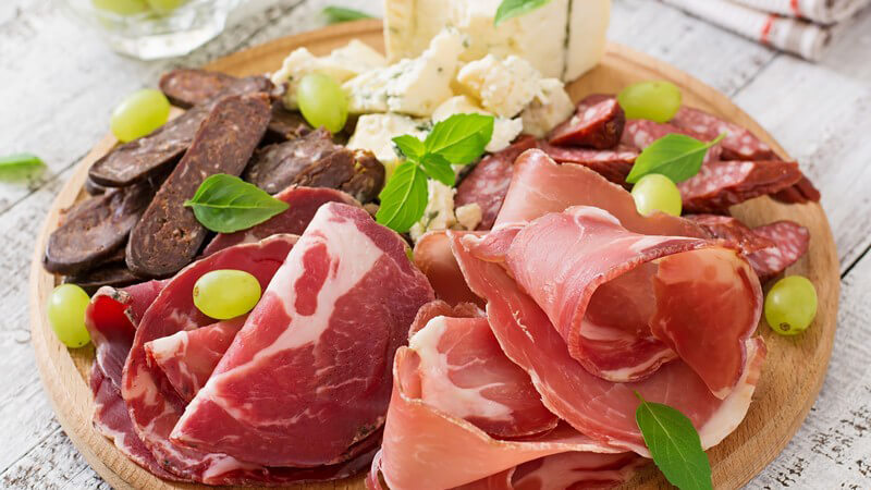 Antipastiplatte mit rohem Schinken, Salami, Schimmelkäse und Weintrauben