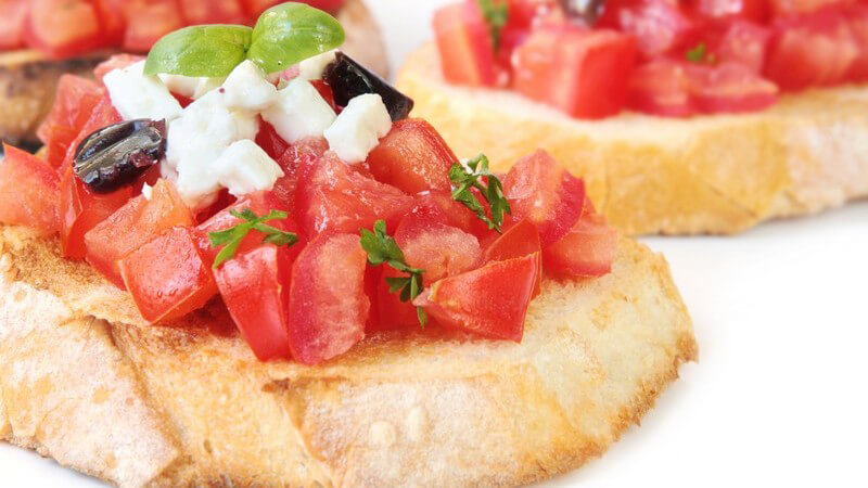 Nahaufnahme Bruschetta, Baguette mit Tomaten, Schafskäse, Basilikum