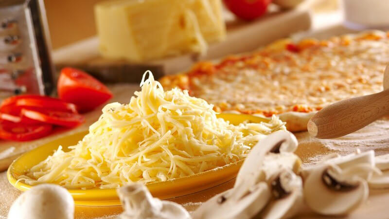 Auswahl an Pizza Zutaten, geriebener Käse, frische Champignons, Tomaten etc.