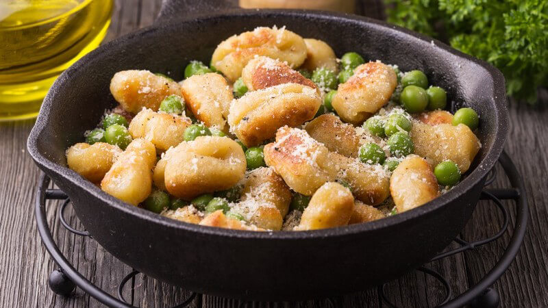 Gusseiserne Pfanne mit selbstgemachten Gnocchi und Erbsen