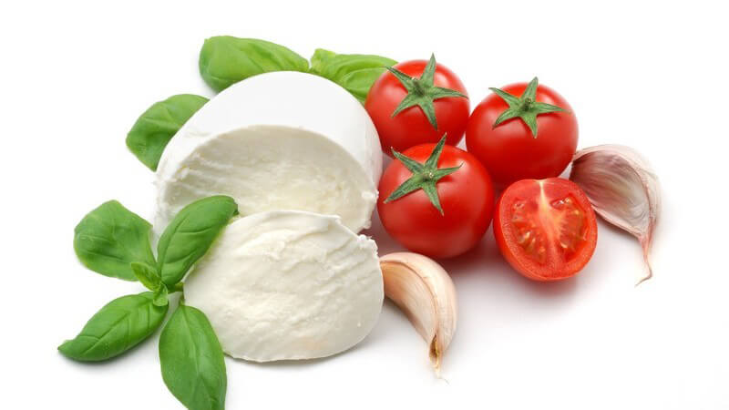 Frsiche Tomaten, aufgeschnittener Mozarella, Basilikumblätter, Knoblauchzehen