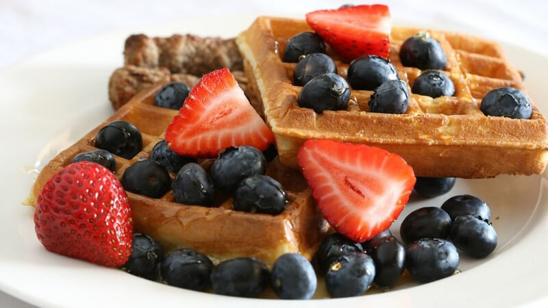 Waffeln mit Heidelbeeren und Erdbeeren auf weißem Teller