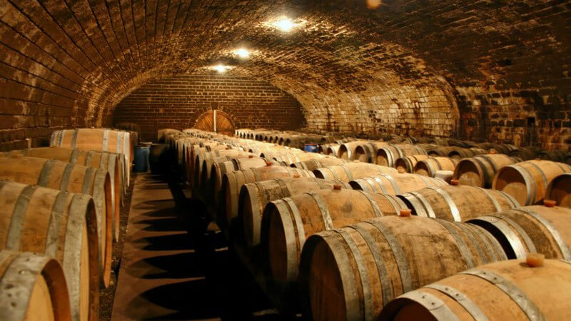 Beleuchteter Kellerraum mit Weinfässern im Lager