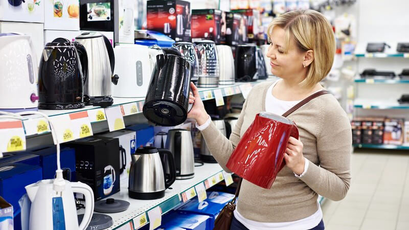 Hausfrau sieht sich im Fachgeschäft nach einem Wasserkocher um