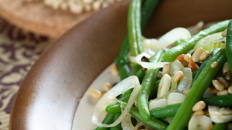 Salat aus grünen Bohnen mit Nüssen in brauner Schale