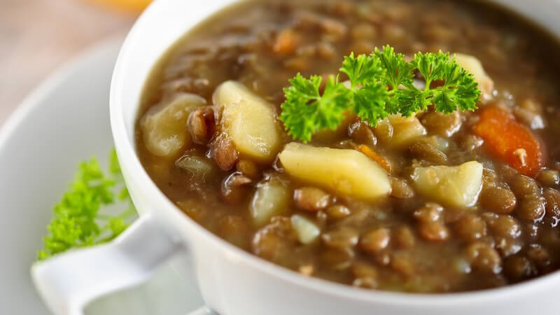 Linsensuppe mit Kartoffeln und Karotten, dekoriert mit Petersilie in Suppenschüssel