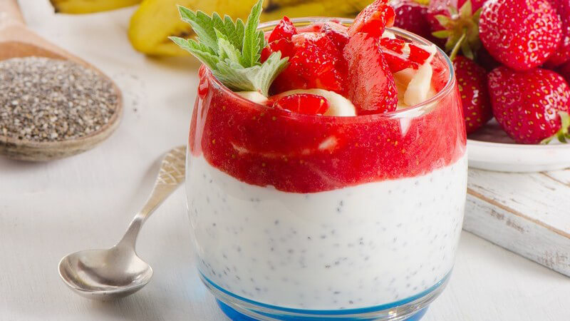 Gesundes Frühstück, Glas mit Joghurt, Banane, Erdbeeren und Chia-Samen