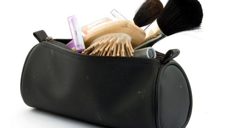 Nahaufnahme Kosmetiktasche mit Rougepinsel, Haarbürste etc.