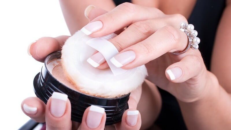 Nahaufnahme Puderdose in Frauenhänden