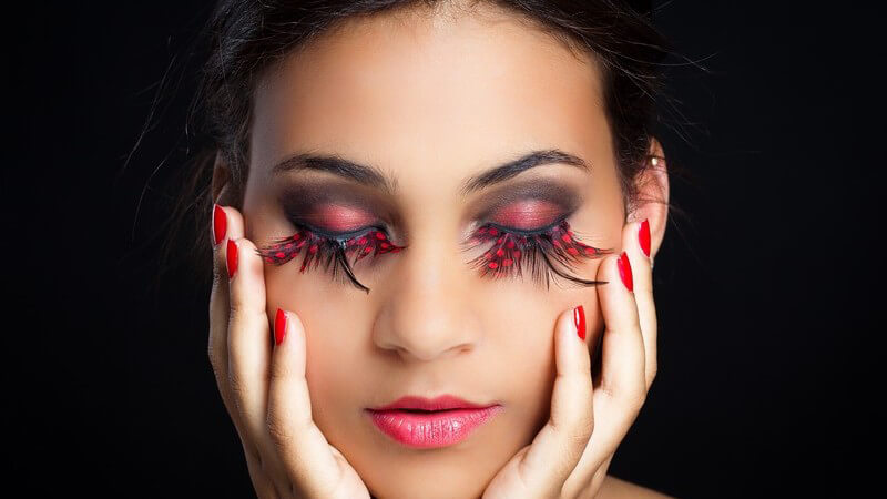 Gesicht einer geschminkten Frau, geschlossene Augen, extrem lange Wimpern