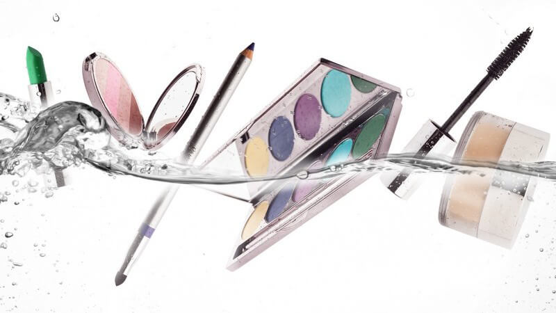Unterschiedliche Make-up-Utensilien schwimmen nebeneinander im Wasser