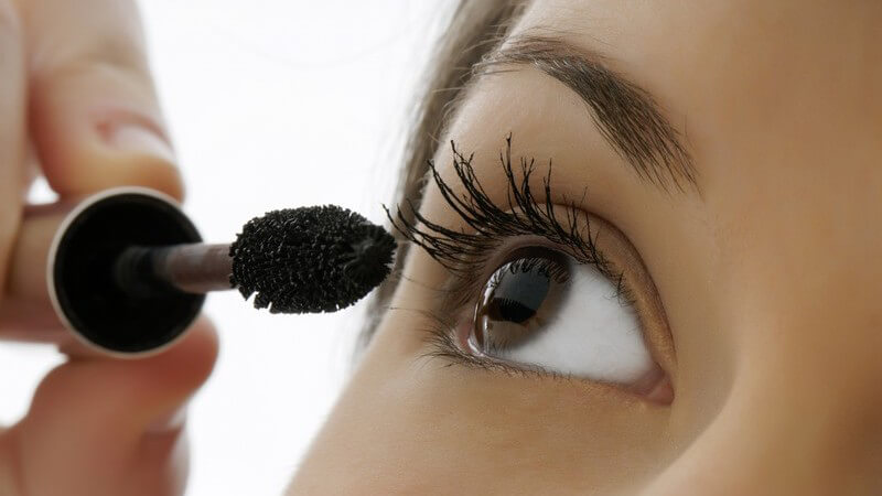 Nahaufnahme Frau mit braunen Augen trägt Mascara auf