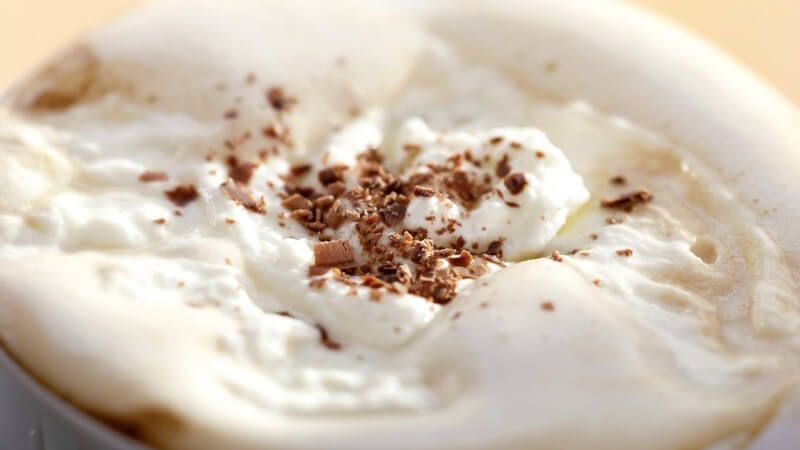 Nahaufnahme Schlagsahne mit Kakao in Tasse